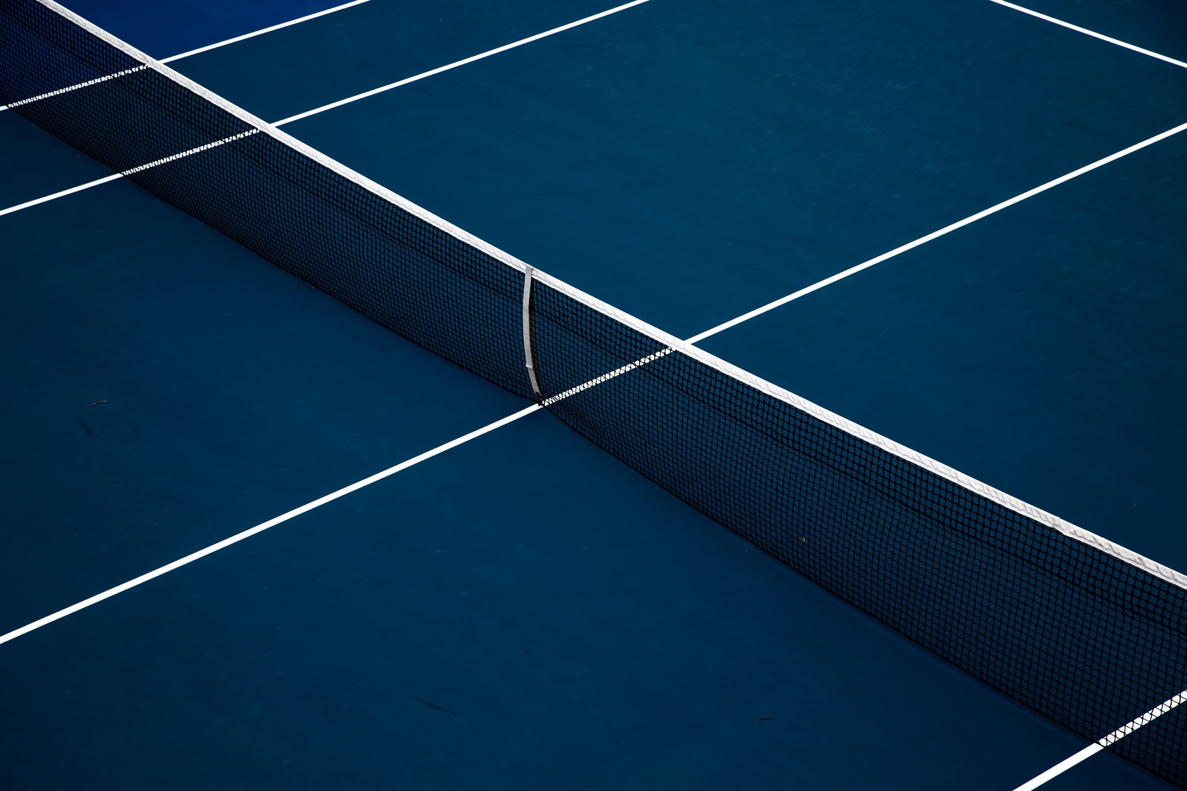 Red de tenis sobre una cancha azul oscura